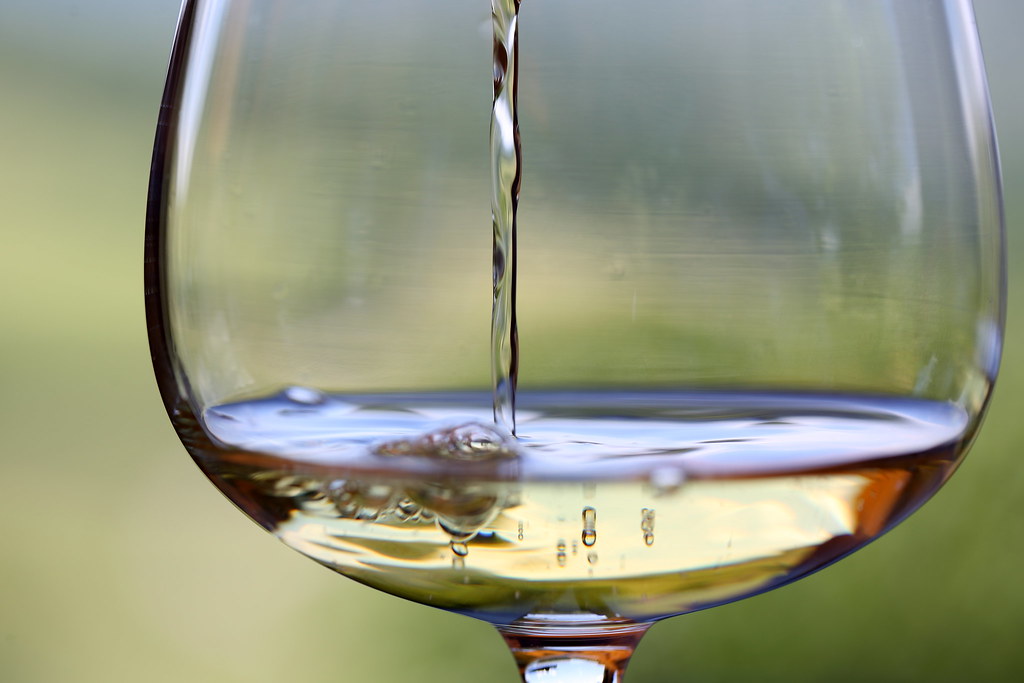 Wein wird in ein Glas eingeschenkt, dabei bilden sich Luftbläschen: Belüftung beim Einschenken